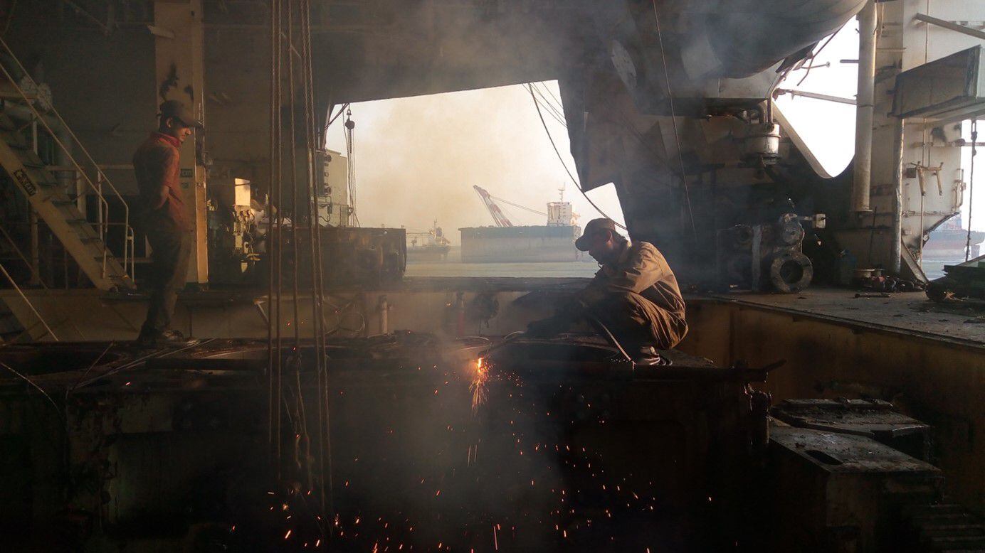 Un trabajador usa un soplete para cortar acero en el interior de un barco en proceso de desguace en Bangladés.