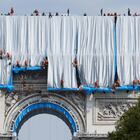 Workers unravel silver blue fabric, part of the process of wrapping L'Arc de Triomphe in Paris on September 12, 2021, designed by late artist Christo. - Work has begun on wrapping the Arc de Triomphe in Paris in silvery-blue fabric as a posthumous tribute to the artist Christo, who had dreamt of the project for decades. Bulgarian-born Christo, a longtime Paris resident, had plans for sheathing the imposing war memorial at the top of the Champs-Elysees while renting an apartment near it in the 1960s. (Photo by Thomas SAMSON / AFP) / RESTRICTED TO EDITORIAL USE - MANDATORY MENTION OF THE ARTIST UPON PUBLICATION - TO ILLUSTRATE THE EVENT AS SPECIFIED IN THE CAPTION