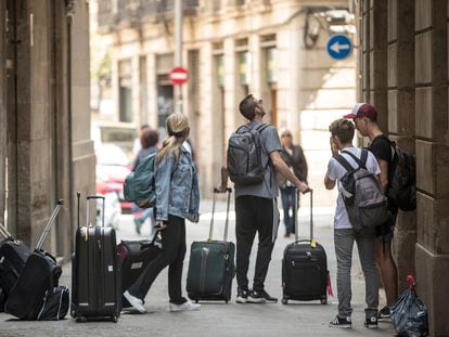 Turistas con maletas ante un edificio del barrio Gòtic de Barcelona, en una imagen de archivo.