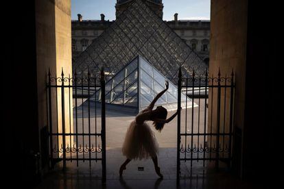 Una bailarina actúa junto a la pirámide del Louvre en París (Francia).