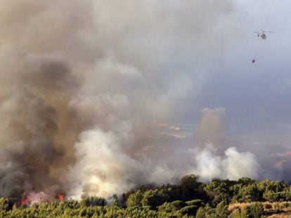 Un helicóptero echa agua al incendio en Charneca, en la sierra de Sintra, esta mañana.