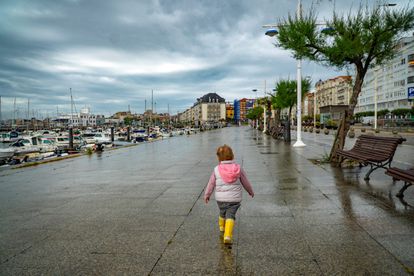 Una niña pasea por Santander este viernes, a pesar de la lluvia esta mañana.