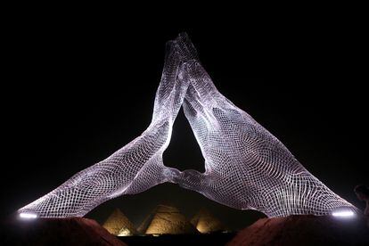 The installation 'Together' by Italian artist Lorenzo Quinn, in front of the pyramids of Giza.