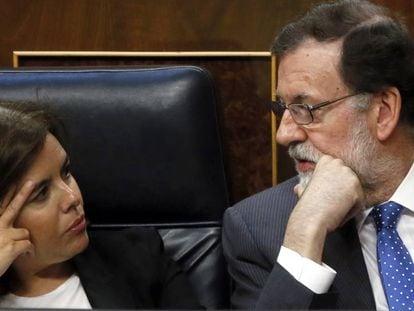 El presidente del Gobierno, Mariano Rajoy, habla con la vicepresidenta, Soraya S&aacute;enz de Santamar&iacute;a, durante el pleno del Congreso.