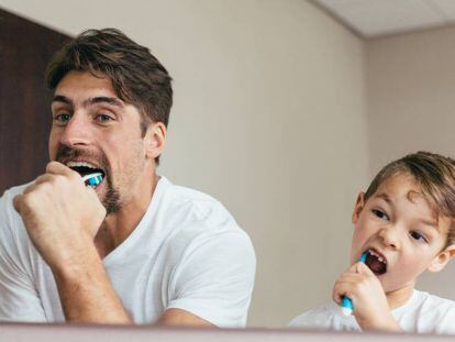 Un padre se lava los dientes con su hijo. 