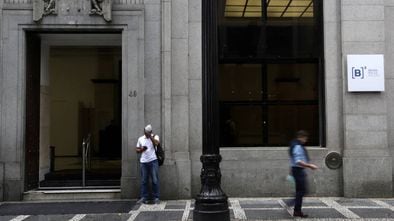 Dos personas, frente al edificio de la Bolsa de São Paulo.