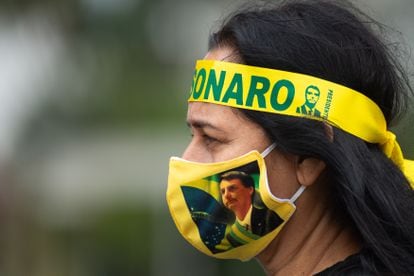 Una partidaria de Jair Bolsonaro usa un cubrebocas con el rostro del presidente brasileño, en mayo de 2020 en Brasilia. 