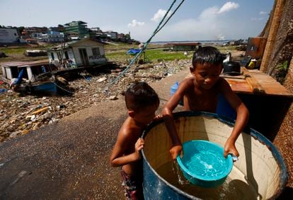 Niños se bañan antes de ir a la escuela, en Manaos (Estado de Amazonas). Más de 110.000 personas han sido afectadas por la sequía, según las autoridades, ya que los peces muertos afectan el acceso a comida y contaminan la principal fuente de agua.