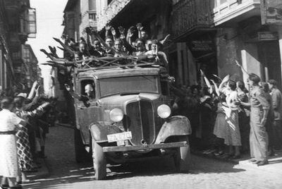 Voluntarios nacionalistas entran en Zamora brazo en alto, siendo correspondidos del mismo modo por los que les recibían en la calle, en fecha no determinada del verano de 1936.