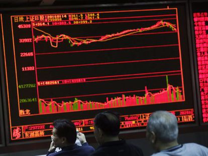 Inversores chinos miran una pantalla con la evolución de los parqués chinos en una casa de corretaje en Pekín (China).