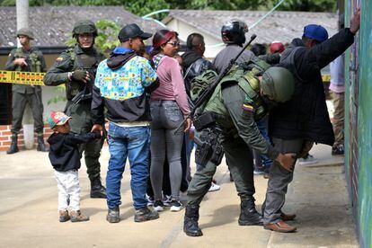 Un oficial de policía revisa a un hombre en un colegio electoral en Toribio, departamento de Cauca, Colombia.