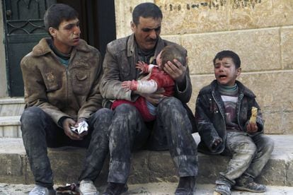 Aman sostienen en brazos a un niño sacado de las ruinas del bombardeo aéreo en Alepo que llevaron a cabo las fuerzas del presidente sirio, Asad. A su lado, otro niño llora.