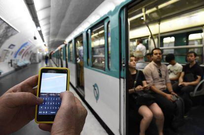 Un hombre sujeta un m&oacute;vil en el metro de Par&iacute;s