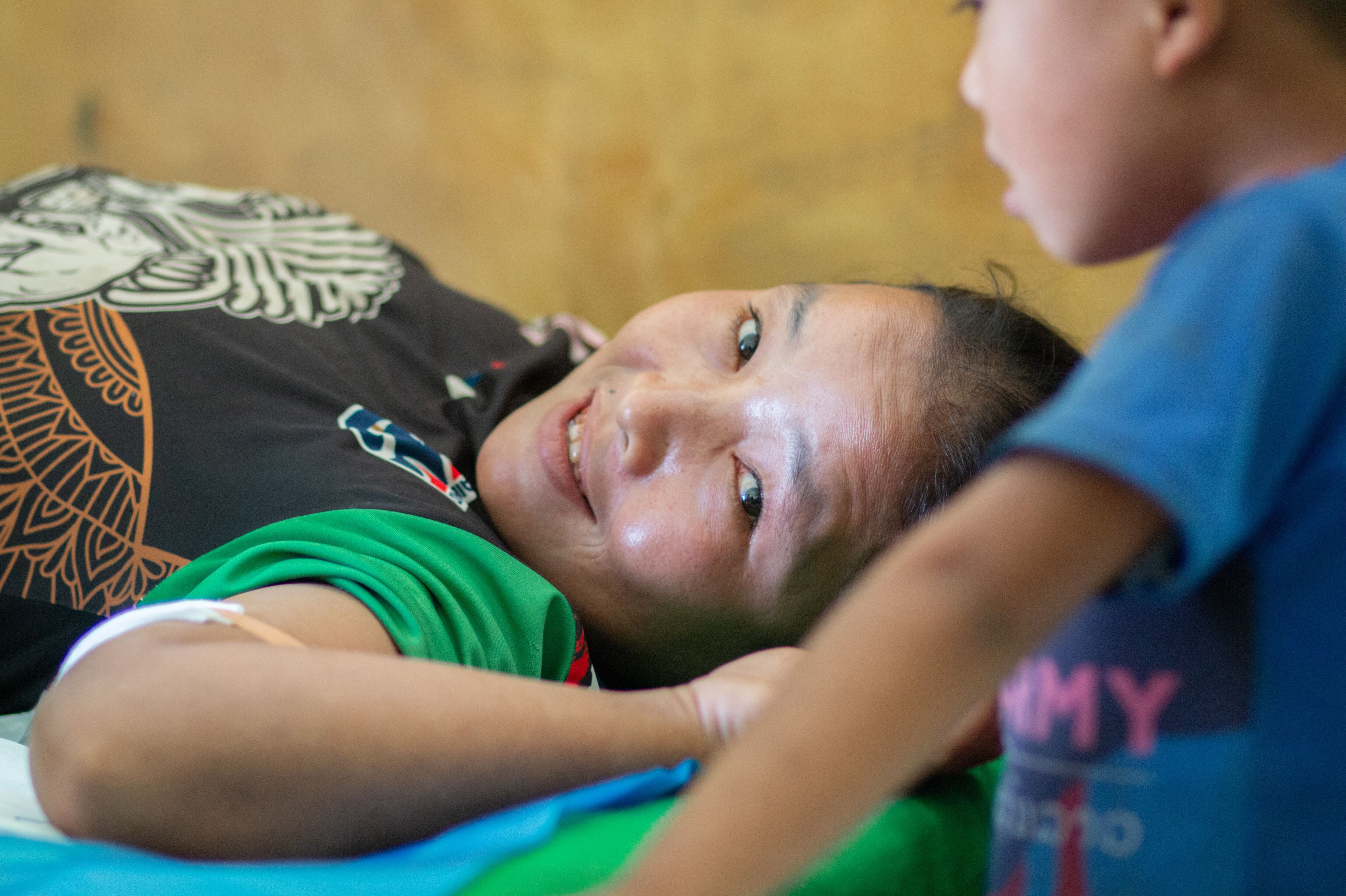 Iso es de una etnia que no habla laosiano y acude al hospital del distrito de Namor, en el norte de Laos, con su marido y su hijo pequeño, para que le pongan un implante anticonceptivo en el brazo derecho. Él traduce a su esposa las explicaciones de la enfermera. 
