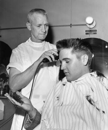 Un peluquero corta el pelo a Elvis Presley, en el primer día del artista en el ejército, en 1958.