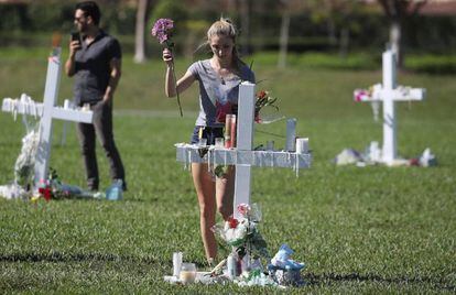 Una joven deposita unas flores en el homenaje a las víctimas en Parkland.