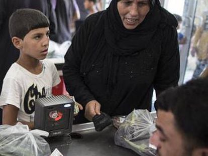 Refugiados compran con una tarjeta de la Media Luna Roja en Sanliurfa (Turqu&iacute;a) en 2015.