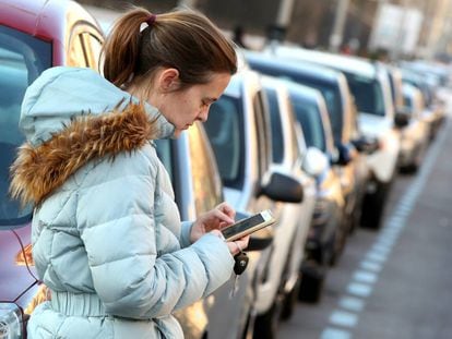Una mujer utiliza una aplicaci&oacute;n m&oacute;vil para pagar el estacionamiento en la zona SER.