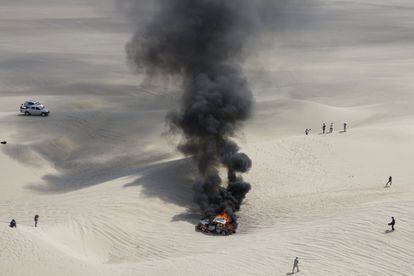 El coche de Alicia Reina y Carlos Dante Pelayo incendiado en la tercera etapa del Dakar en Pisco (Perú), el 8 de enero.