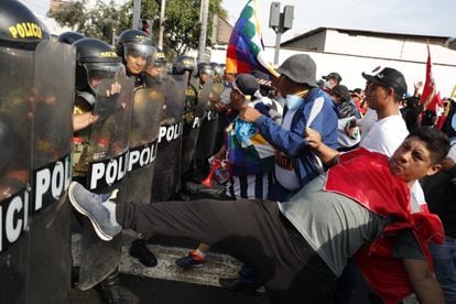  Manifestantes forcejean con miembros de la policia en Lima. 