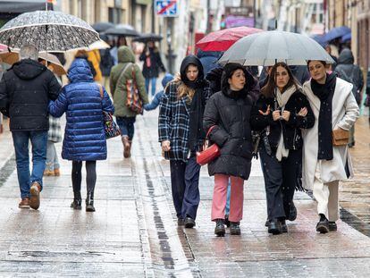 Varias personas pasean con paraguas y muy abrigados en la calle Portales de Logroño, el pasado domingo.