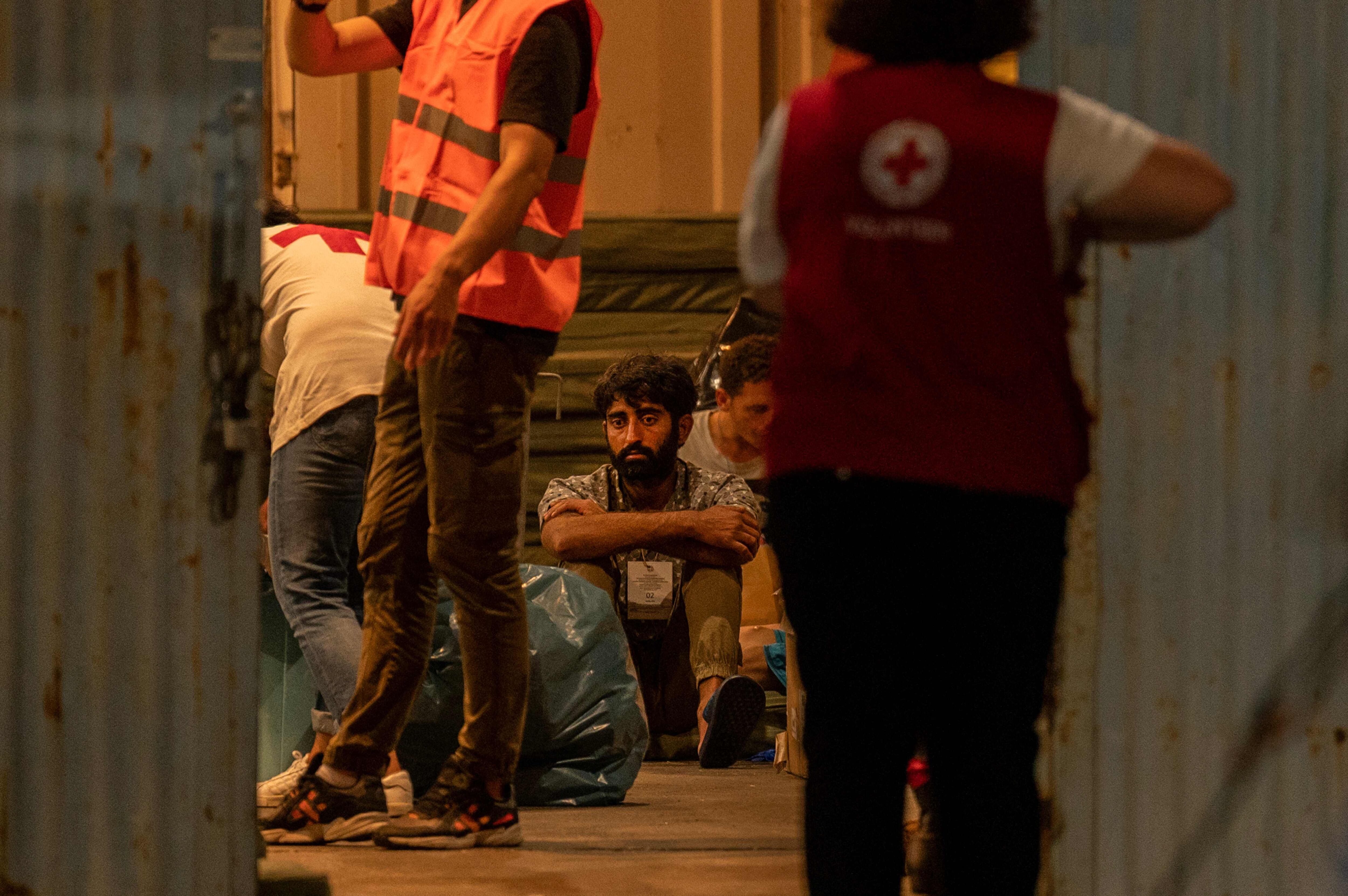 Un migrante superviviente descansa en un almacén junto al personal médico en el puerto de Kalamata (Grecia), el miércoles.