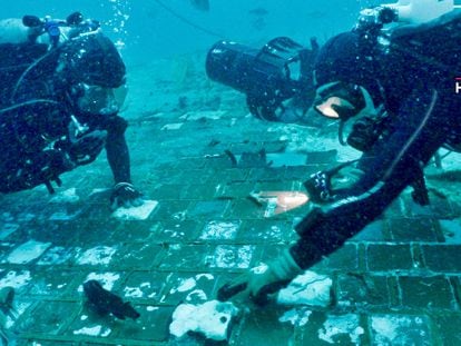 Dos investigadores submarinos exploran un segmento del transbordador espacial 'Challenger', descubierto por el equipo en las aguas de la costa de Florida durante el rodaje de un documental de 'History Channel'