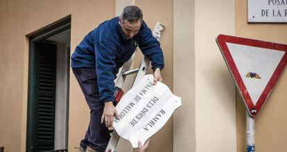 Un operario retira la placa de la calle de Los duques de Palma de Mallorca, el pasado febrero. 