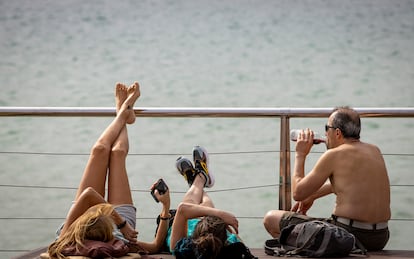 Varias personas descansan junto a la orilla de la playa de La Concha de San Sebastián este miércoles, en el que se han alcanzado los 30 grados.