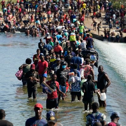 Haitian migrants use a dam to cross to and from the United States from Mexico, Friday, Sept. 17, 2021, in Del Rio, Texas. Thousands of Haitian migrants have assembled under and around a bridge in Del Rio presenting the Biden administration with a fresh and immediate challenge as it tries to manage large numbers of asylum-seekers who have been reaching U.S. soil. (AP Photo/Eric Gay)