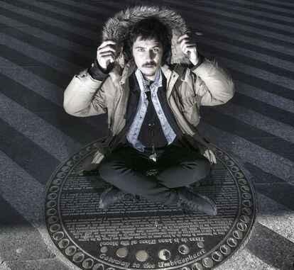 Paco Bezerra, sentado en la placa en el suelo de la plaza de la Luna que dice que all&iacute; hay un portal a la umbraesfera.