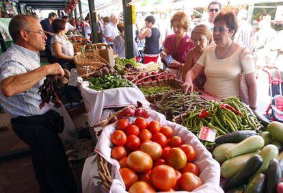 Un tendero atiende ayer a varias clientas en el Mercado de San Lorenzo de Algorta.