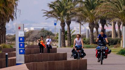 Ciclistas y peatones en el paseo marítimo de la playa de El Toyo en Retamar, Almería.
