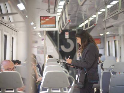 Una interventora controla si los pasajeros viajan con billete en Rodalies.
