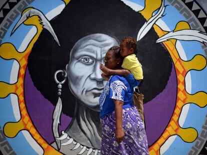 Una mujer de Papúa camina frente a un mural en el centro de Port Moresby, el 13 de noviembre de 2018, antes de la cumbre de Cooperación Económica Asia-Pacífico (APEC).