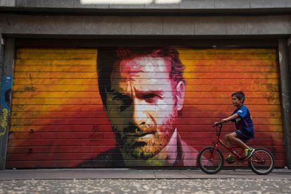 Un niño pasa frente a un graffiti que reetrata al actor Andrew Lincoln en su papel de Rick Grimes, de la serie The Walking Dead.