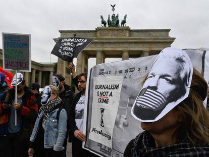 Manifestantes protestan por el arresto de Assange con máscaras con su cara, este jueves en Berlín.