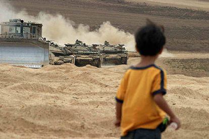 Un niño palestino observa los tanques israelíes en las cercanías del campo de refugiados de Yabalia, en la Franja de Gaza.