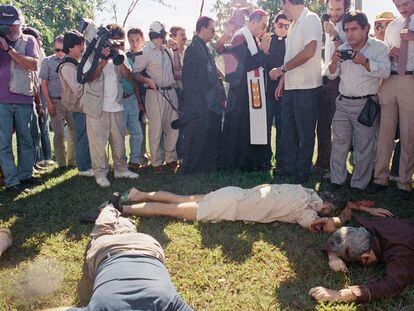 El arzobispo de El Salvador, rodeado de periodistas, junto a los cadáveres de las víctimas, en 1989.