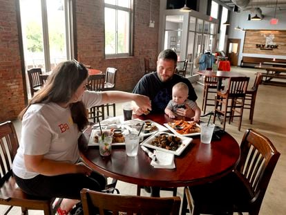 Una pareja come con su hijo pequeño en un restaurante de Pensilvania.