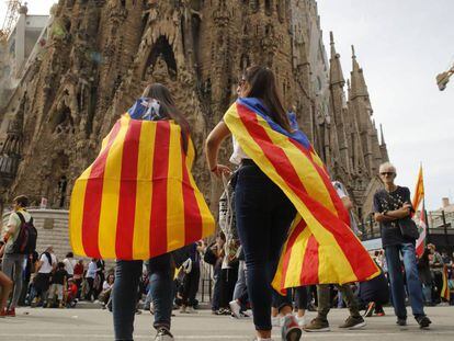 Dos jóvenes observan el cierre del acceso principal de la Sagrada Familia en Barcelona. 