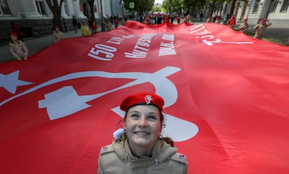 Una joven homenajea a los Pioneros soviéticos en Sebastopol con una bandera con la hoz y el martillo. 