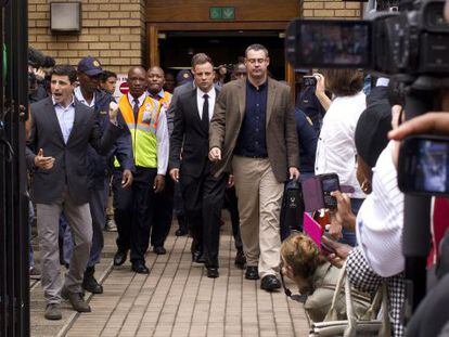 Pistorius (en el centro, con corbata), al salir hoy del tribunal.