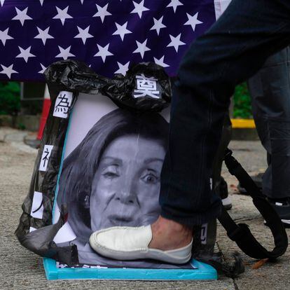 Pro-China supporters step on a picture of U.S. House Speaker Nancy Pelosi during a protest outside the Consulate General of the United States in Hong Kong, Wednesday, Aug. 3, 2022. U.S. House Speaker Nancy Pelosi arrived in Taiwan late Tuesday, becoming the highest-ranking American official in 25 years to visit the self-ruled island claimed by China, which quickly announced that it would conduct military maneuvers in retaliation for her presence. (AP Photo/Kin Cheung)