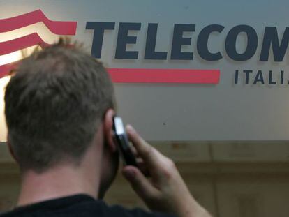 Un usuario habla por m&oacute;vil junto a un logo de Telecom Italia. 