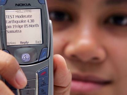 Una mujer muestra un SMS del centro de monitoreo de tsunamis en Kuala Lumpur, en 2005.