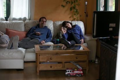 Una familia viendo la televisión en el salón de su casa.