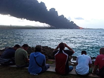 Un grupo de personas observa el humo ocasionado por una nueva explosión en el parque de tanques de Matanzas.