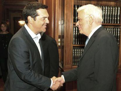 El primer ministro griego, Alexis Tsipras, estrecha la mano del presidente griego, Prokopis Pavlopoulos, tras anunciar su dimisi&oacute;n.