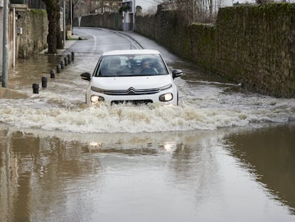 Un vehículo atraviesa una de las zonas donde el río Arga se ha desbordado a su paso por Pamplona, este lunes.